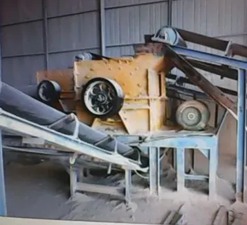 Dust-covered machinery and a conveyor inside a factory shed.
